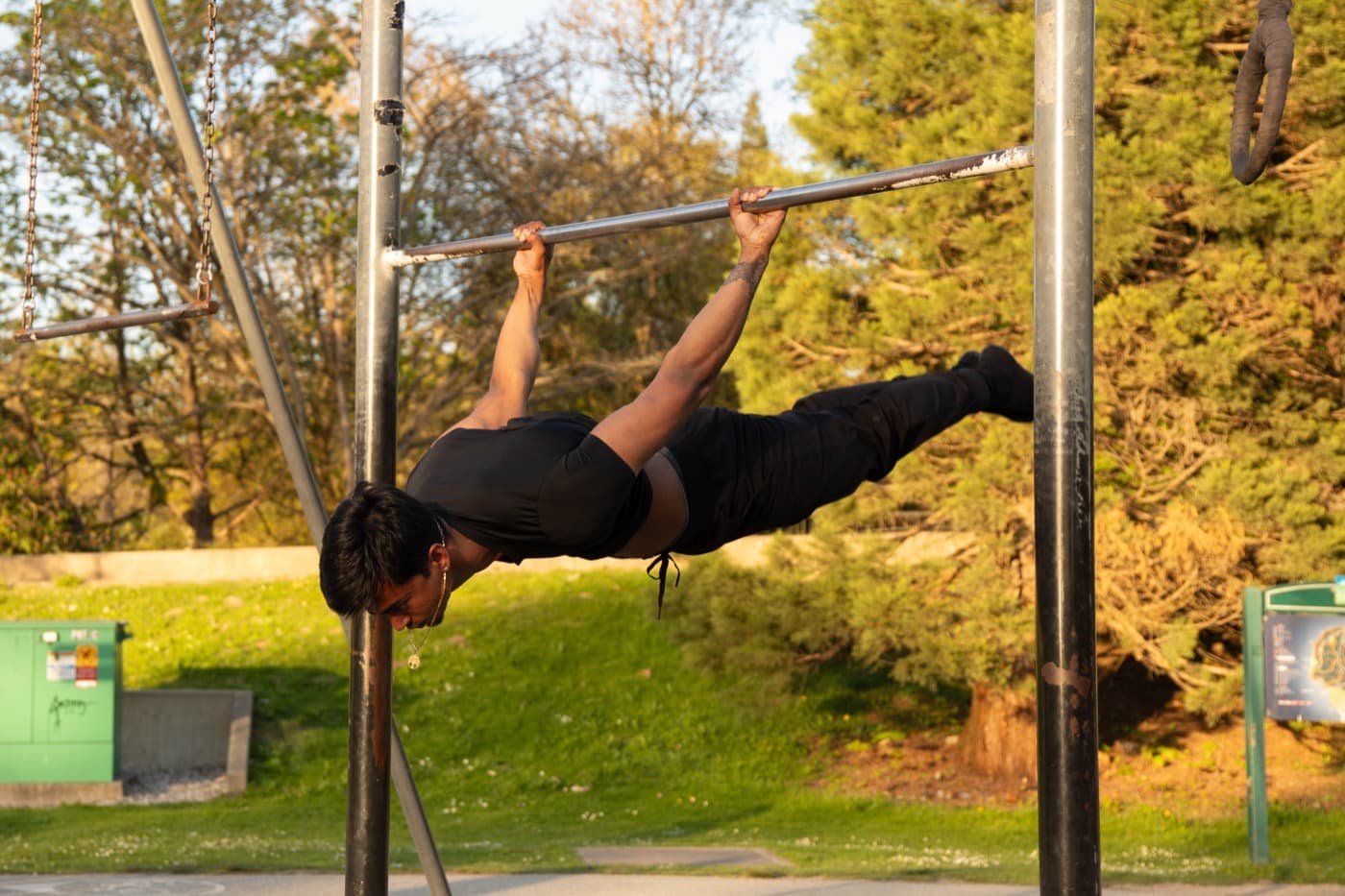 Saran holding a back lever on an outdoor bar